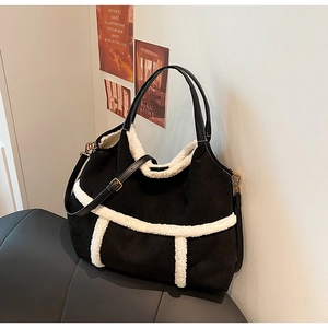 Détail du sac cabas en daim noir avec bordure en molleton blanc et ferrures dorées