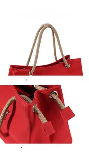 Detail of red linen canvas tote bag showing braided rope handles and metal eyelets