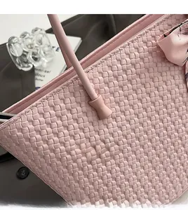 Close-up of woven tote bag with smooth hand-stitched edges and floral silk bow detail