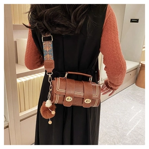 Detail of vintage brown Boston bag with metal studs and patterned shoulder strap