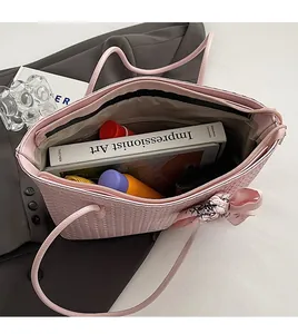 Internal view of pink woven tote bag showing large capacity for books and cosmetics