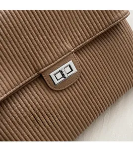 Detailed macro view of the silver twist lock and pleated texture on brown tote bag