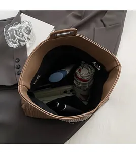 Top view of spacious interior of brown pleated tote bag with various daily essentials