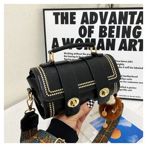 Detail of black pebbled leather Boston bag with gold turn-locks and ethnic strap