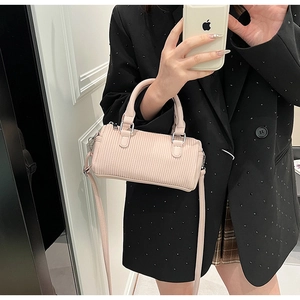 Macro detail of pink textured leather barrel bag with silver hardware and dual handles