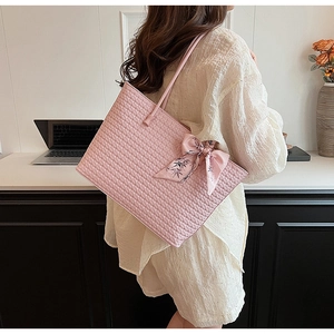 Close-up of pink woven tote bag featuring floral scarf detail and premium PU leather texture