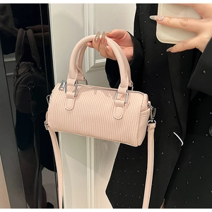 Detailed close-up of pink pleated cylinder handbag with silver hardware and shoulder strap