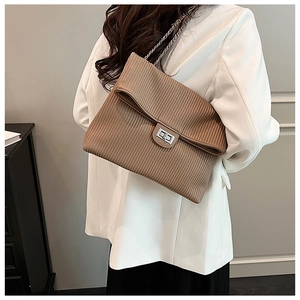 Close-up of brown pleated shoulder bag with silver twist lock and chain strap