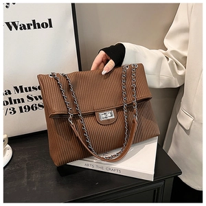 Brown corduroy shoulder bag with silver turn-lock and chain strap in a lifestyle setting