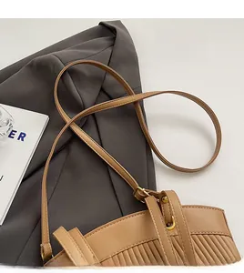 Detail of khaki pleated tote with adjustable strap and polished gold hardware