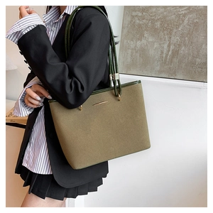 Olive green matte tote bag with slim shoulder straps and gold metal detail shown on model