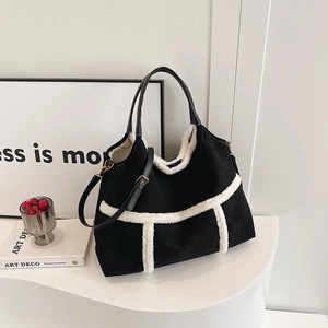Sac cabas noir avec bordure en peluche et poignées en cuir dans un décor minimaliste