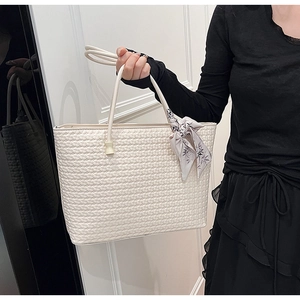 Detail of white woven tote bag texture with elegant floral silk scarf accessory