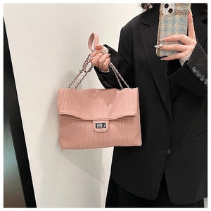 Detail of pink pleated tote bag featuring silver chain strap and metal turn-lock closure