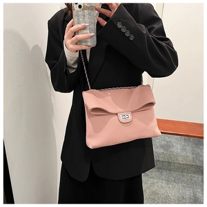 Detail of pink pleated tote bag with silver chain strap and metal swivel lock on model