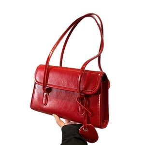 French vintage red leather underarm bag with a heart-shaped charm and long handle strap