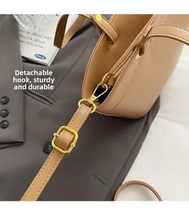 Detail of detachable metal lobster clasp and adjustable buckle on leather tote bag