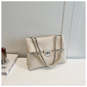 Detail of off-white corduroy tote with silver chain strap and metal swivel lock