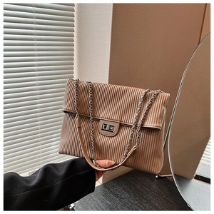 Close-up of vintage corduroy tote with metal turn-lock and chain strap detail