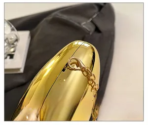 Close-up of gold mirror evening bag showing luxury hardware and metal chain strap