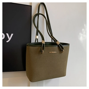 Detail of olive green tote bag featuring matte fabric texture and gold metal accents
