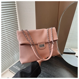 Detail of pink corduroy tote bag with silver twist lock and chain strap texture