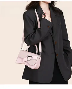 Close-up of pink leather handbag featuring woven flap texture and D-ring metal hardware