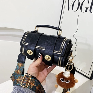 Retro black cylindrical Boston bag with gold rivets and colorful patterned wide strap