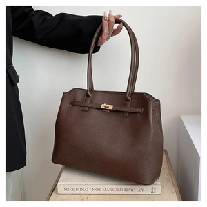 Macro view of dark brown leather tote with fine texture and golden twist lock closure