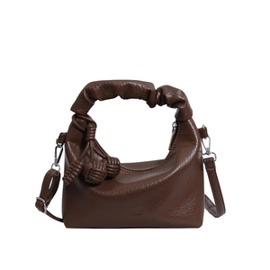 Dark brown leather hobo bag with pleated handle and woven tassel detail shown on white background