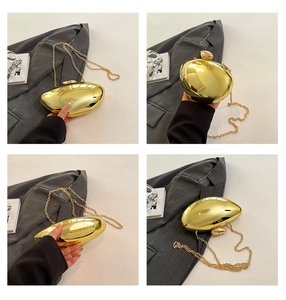 Detail view of the metallic gold pebble evening bag with a sleek snake chain strap