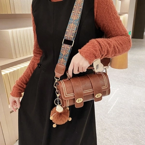 Brown vintage Boston bag with gold rivets and patterned shoulder strap on model