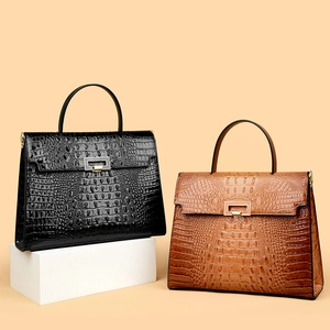 Close-up of crocodile-embossed texture on vintage trapezoid handbags with metal buckles
