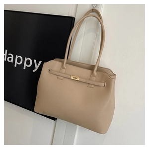 Detail of beige faux leather tote with fine pebble grain texture and gold metal twist lock