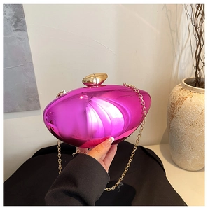 Detail of rose pink metallic clutch bag with golden shell clasp and acrylic chain