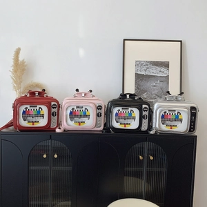 Detailed view of four retro TV-shaped handbags with transparent window in various colors