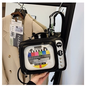 Detailed view of a retro television shaped crossbody bag with colorful test signal screen