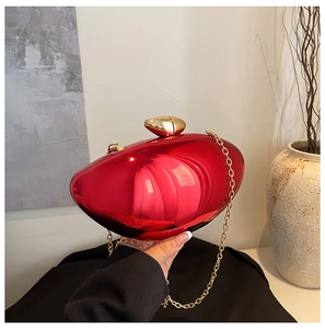 Detail of red metallic evening bag with gold pebble clasp and acrylic chain strap