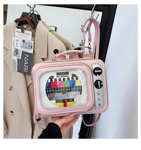 Close-up of pink vintage TV-shaped bag featuring 'NO SIGNAL' screen and silver knobs