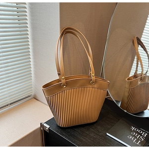Detail of light brown leather tote bag featuring pleated texture and gold metal buckle