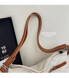 Detail of adjustable leather strap and silver buckle on canvas tote shoulder bag