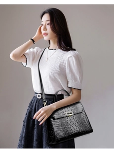 Detail of black crocodile texture and golden swivel lock on a vintage handbag
