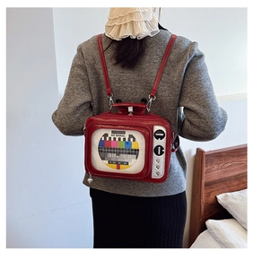Rear view of a red TV-shaped backpack with NO SIGNAL pattern on a female model