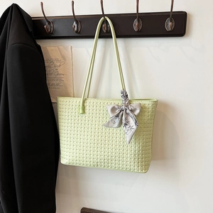 Light green woven tote bag with floral scarf detail on minimalist metal hanger