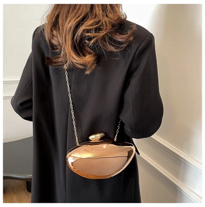 Detail of rose gold metallic clutch bag with unique irregular geometric shell shape