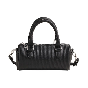 Minimalist black quilted barrel bag with silver hardware and detachable strap for women