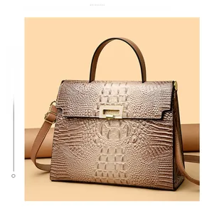 Close-up of khaki crocodile embossed texture and golden metal lock on a vintage handbag