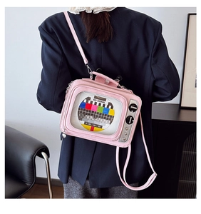 Pink retro TV crossbody bag with clear screen and no signal graphic worn by a model