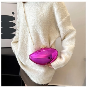 Detail view of a rose pink egg-shaped clutch with gold chain and polished mirror finish
