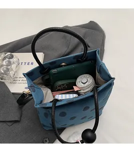 Spacious interior of polka dot tote bag showing storage for tablet, umbrella and phone